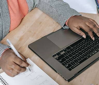 Person Typing and Writing on Computer